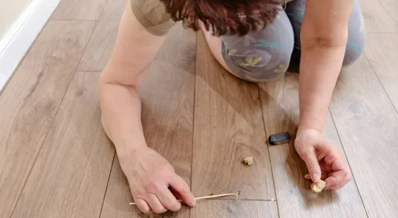 Personne bouchant un trou sur un plancher de bosi franc
